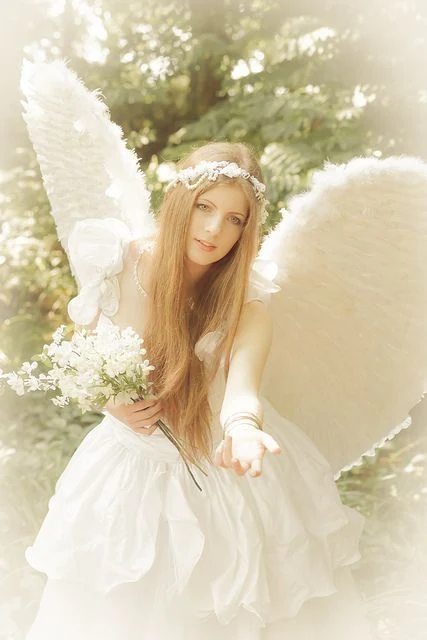 Ángel con grandes alas blancas y corona de flores que tiende la mano y ofrece un ramo de flores