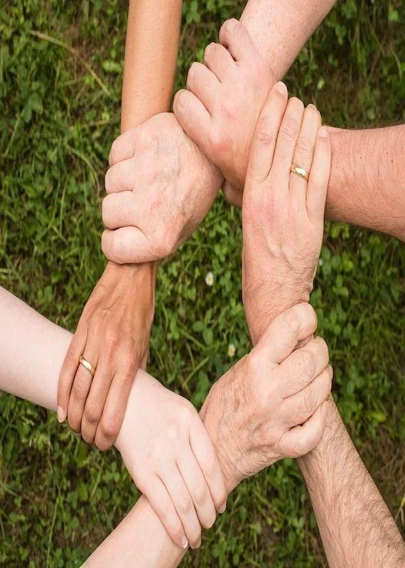 Manos de varias generaciones unidas en círculo, símbolo de las constelaciones familiares