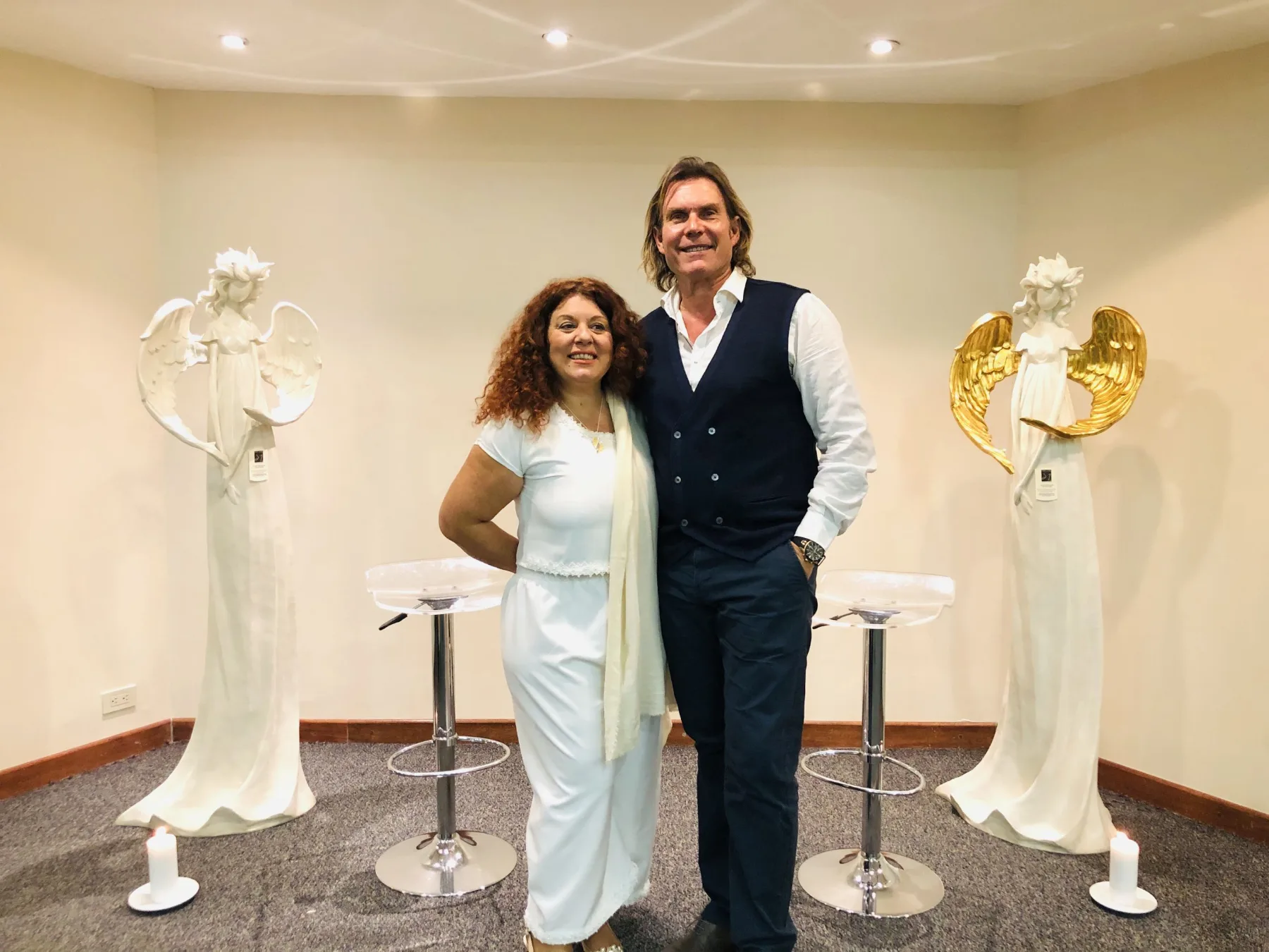 Nuria López and Pere Pascuet at a talk about angels next to angel sculptures